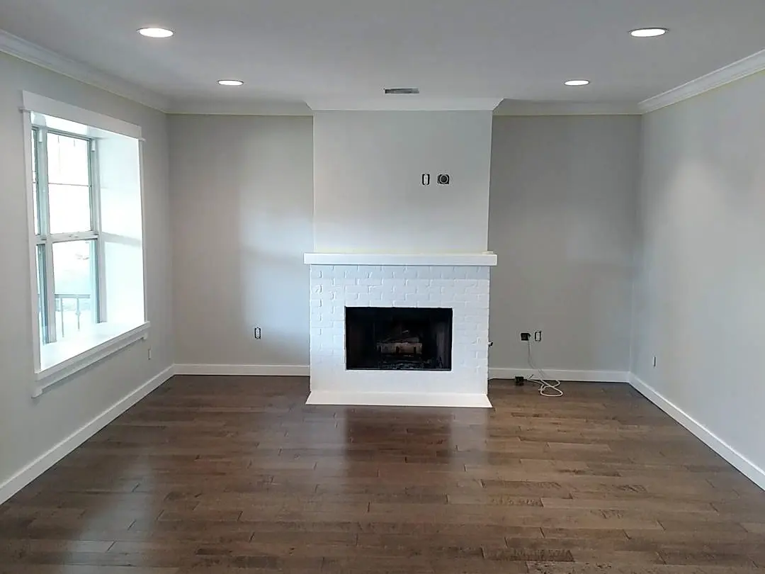 Finished light-gray residential interior with crisp white trim and a dark fireplace wall.